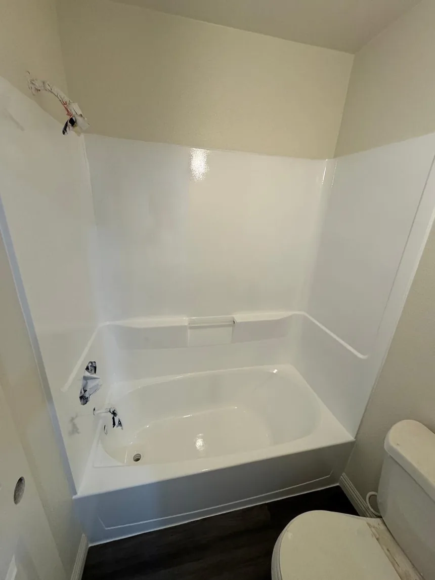 The same one-piece unit refinished, tub and surround both in gloss white.