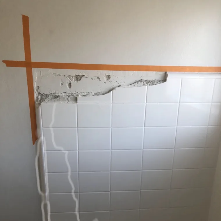 The repaired area sanded flush, with the tile edge straight again.