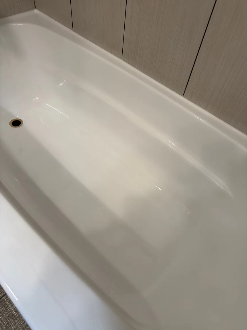 A close view of a finished bathtub, the new surface even and glossy along the whole edge.